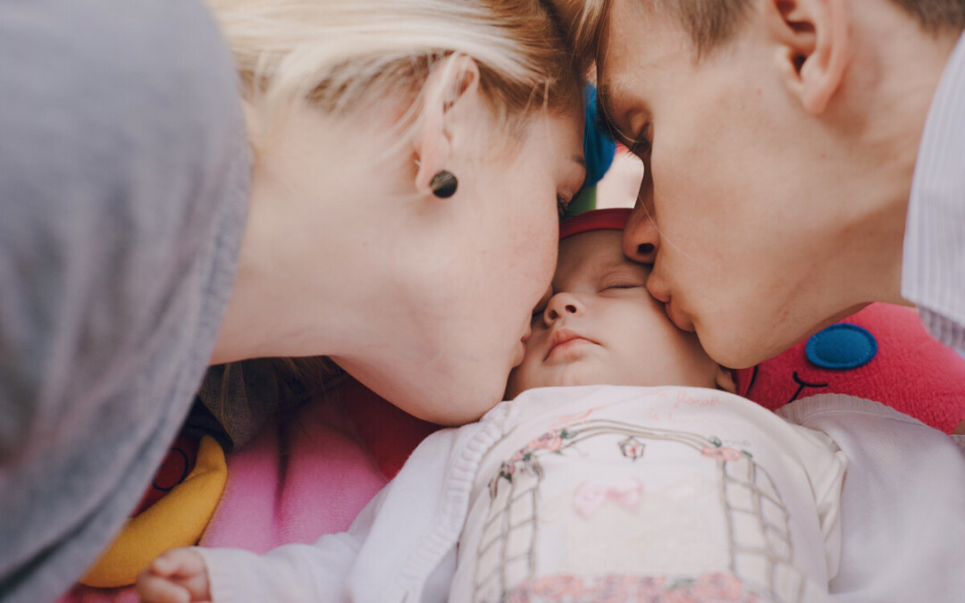 De jeunes parents embrassent leur nouveau-né